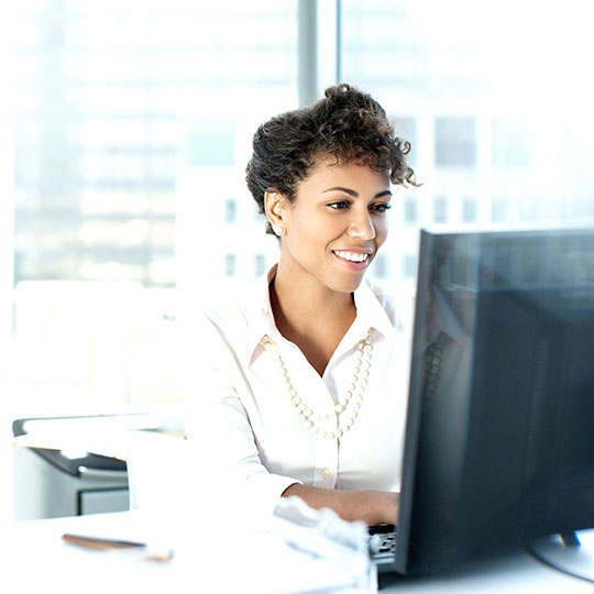 vrouw aan het werk achter een desktop computer